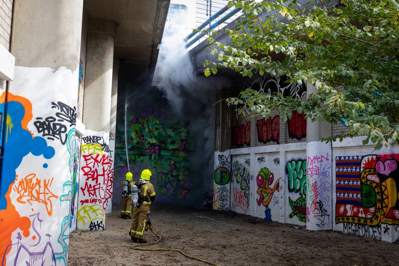 Rookontwikkeling over treinspoor door brandende scooter Rotterdam